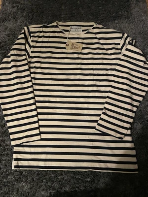 Randig långärmad t-shirt - Säljer en tvärfet randig långärmad T-shirt i storlek m. Tröjan är i archive/y2k stil och passar perfekt i både kallare och varmare väder. Passar längder runt 185 cm. Tveka inte att höra av dig, priset är självklart diskuterbart! 