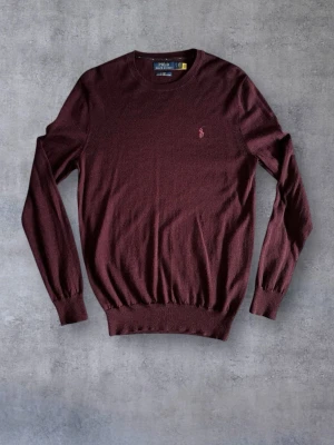 Polo Ralph Lauren Slim Fit Washable Merino Wool Jumper - Jättesnygg Ralph Lauren merinoull crewneck i storlek S. Elegant vinröd-färg och i 100% merinoull. Modell: Slim fit.  Mått Axelbredd: 40 cm Längd: 70 cm
