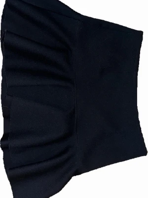 Svart volangkjol från H&M, storlek 36 - Säljer en svart kortkjol från H&M i storlek 36. Kjolen har en snygg volangkant nedtill och är tillverkad i ett strukturerat syntetmaterial. Den har en diskret dragkedja bak för enkel på- och avtagning. Perfekt för dig som gillar stilrena och trendiga plagg.