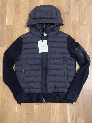 Mörkblå Moncler Cardigan - Säljer en Mörkblå Moncler Cardigan. Storlek M men passar bättre som S. Nfc funkar inte. Nyskick. Priset är inte hugget i sten.