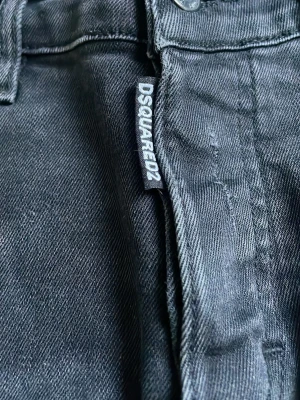 Svarta jeans från Dsquared2 - Säljer ett par svarta jeans från Dsquared2 med slitningar och trasiga detaljer på benen. Jeansen har en klassisk femficksmodell. Snygga att matcha med sneakers eller boots.