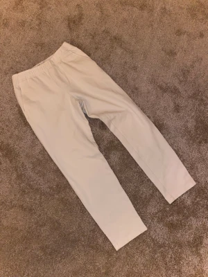 Beiga mjukisbyxor från Zara - Säljer ett par beiga mjukisbyxor från Zara i storlek S. Byxorna har elastisk midja och raka ben, vilket gör dem riktigt sköna och enkla att bära. Perfekta för chill dagar eller när du vill ha en clean och enkel look.