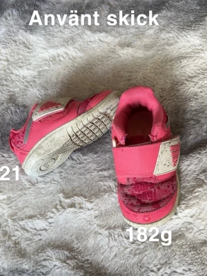 Rosa Adidas sneakers med kardborre - Säljer ett par rosa Adidas sneakers med praktisk kardborreknäppning och vit sula. Perfekta för dig som gillar färgglada och sportiga skor🌸 .Använd skick. Hela men skav. Stl 21