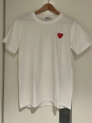 Comme Des Garçons T-Shirt  - Säljer en vit t-shirt från Comme des Garçons Play. Den är aldrig använd, bara vid provning. Tröjan har inga fläckar eller slitage. Skriv gärna för mer bilder eller information.😁