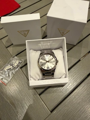 GUESS klocka - Säljer en GUESS klocka i mycket bra skick. Använd endast 3-4 gånger. Urverket är 4,2cm i diameter och är vattentät i upp till 50m. 100% stainless steel. Riktigt fin klocka! Extralänkar och förpackning medföljer