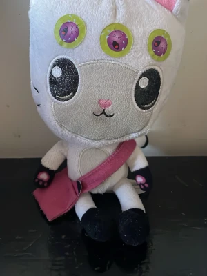 Ingen väst på bilden - Bilden visar ett gosedjur med en rosa väska, men ingen väst syns på bilden.