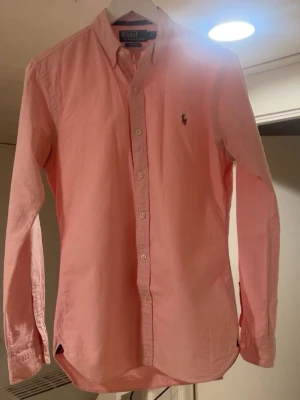 Ralph Lauren skjorta - Säljer denna rikigt schyssta Ralph Lauren skjortan i storlek S. Skjortan är i slim fit och den eftertraktade rosa färgen!🤩Skjortan är så gott som ny. Bara att höra av sig vid frågor!