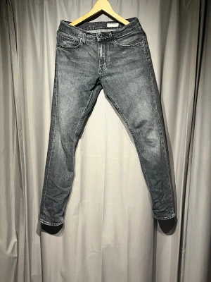 Grå jeans från Tiger of Sweden - Snygga grå jeans från Tiger of Sweden med klassisk femficksdesign och raka ben. Jeansen har en mörkgrå tvätt . Materialet är robust denim och passformen är normal med midwaist. Nypris 1700kr 29 32