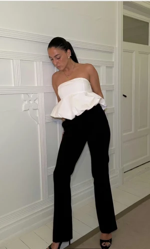 Svarta kostymbyxor med bootcut - Snygga svarta lågmidjade kostymbyxor med bootcut och slits. I storlek 34. 