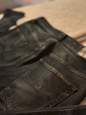 Gråblå nudie jeans  - Grå blå jeans från nudie, bra skick, storlek W32 L32. Ganska unika jeans, ser ut som mörkgrå men kollar man noggrant ser man dom väldigt mörka blå dragen. bra jeans för bra pris. Inte fast pris