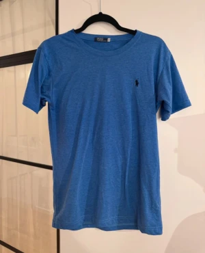 Blå t-shirt från Ralph Lauren - Snygg blå t-shirt från Polo Ralph Lauren i storlek S. Klassisk design med rund hals och korta ärmar.