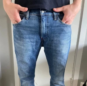 Levi's 511 blå jeans - Säljer ett par Levi's 511 Premium jeans i klassisk blå tvätt. Modellen normal midja och fem fickor. Jeansen är tillverkade i slitstarkt bomullsjeansmaterial och har den ikoniska röda Levi's-taggen bak. Perfekt för dig som gillar tidlös stil. Skriv gärna frågor!