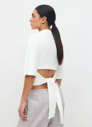 Vit knyttopp från Gina Tricot - Säljer en vit knyttopp från Gina Tricot i storlek S. Toppen har trekvartsärmar och knytband i ryggen som ger en snygg och trendig look. Perfekt att styla med jeans eller kjol för en clean vibe.