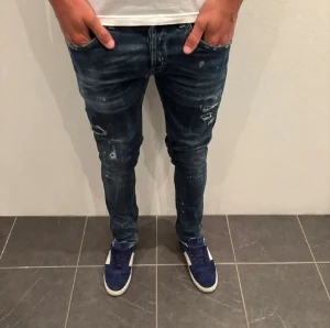 Dondup gegorge w 34 - Säljer ett par dondup gegorge  jeans i mörkblå tvätt med slitningar och lätt distressed detaljer. Skinny fit med normal midja och klassiska fem fickor. Jeansen är gjorda i stretchig bomull för skön passform och har dragkedja i gylfen.
