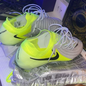 Nike Phantom GT2 fotbollsskor grå/gul - Säljer mina phantoms i bra skick, lägg prisförslag så kommer vi överens om ett schysst pris för just dig. Storlek 44 men passar 43 1/3, priset är lågt för att dom är lite slitna men fortfarande ett bra skick