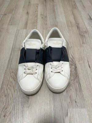 Valentino Garavani vita sneakers - Snygga vita sneakers från Valentino Garavani med mörkblåa detaljer. Perfekt för dig som vill ha snygga skor året runt. Kartong och allt följer med som ni ser på sista bilden. Om ni har några frågor så är det bara att skriva.