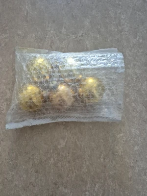 Julkulor - Säljer ett set med klassiska julgranskulor i blank guldig färg. Kulorna är runda och har metallfäste för enkel upphängning i granen. Perfekta för att maxa julkänslan och ge granen en lyxig vibe. Levereras i bubbelplast för extra säkerhet.