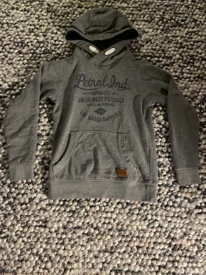 Petrol industries hoodie - Grå hoodie från Petrol Industries i storlek XXS/152-164 cm. I mycket fin kvalitet eftersom jag använt endast 3 gånger då den var för liten för mig. Hoodien är perfect till en unik men avslappnad still på grund av att luvan har en unik och snygg form. Skriv till mig om funderingar om hoodien! 👍⭐️