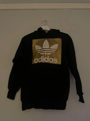 Adidas Hoodie  - Säljer denna adidashoodie med stort adidasmärke på framsidan av tröjan. Osäker på storleken men passar dig som är mellan 170-175