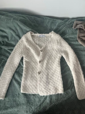 Vit stickad kofta från Zara - Säljer en mysig vit stickad kofta från Zara med grov struktur och tre snygga knappar framtill. Aldrig använd🩷 
