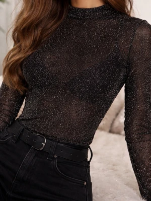Glittrig svart polotopp Gina Tricot XS - Säljer en svart långärmad polotopp från Gina Tricot i storlek XS. Toppen är glittrig med en tunn, transparent look och har en tight passform. Perfekt till nyår!!