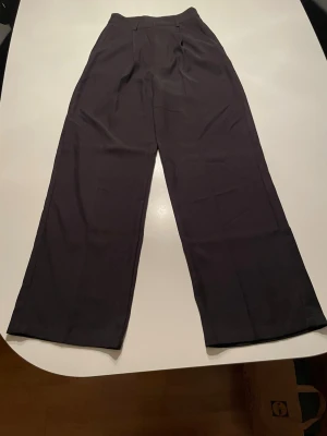 Svarta wide kostymbyxor från Cider - Säljer ett par svarta kostymbyxor från Cider i storlek XXS. Byxorna har hög midja och ett wide snitt med raka ben.