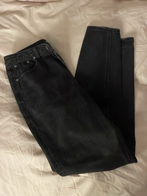 Svarta jeansbyxor från OBJECT M - Säljer ett par svarta jeansbyxor från OBJECT i storlek M. Klassisk femficksmodell med rak passform och normal midja. Snygg detalj med broderad text 'I am the story' på insidan av linningen. Perfekta till sneakers eller boots.