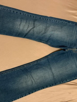 Levi's Superlow Boot jeans blå - Säljer ett par Levi's Superlow Boot jeans i klassisk blå tvätt. Modellen har låg midja och bootcut-ben, vilket ger en chill och retro vibe. Jeansen har fem fickor och Levi's röda logotagg på bakfickan. Perfekt för dig som gillar 00-talsstilen. Knappt använda, 500kr pris kan diskuteras 