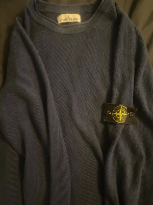 Marinblå stickad tröja Stone Island XL - Säljer en marinblå stickad tröja från Stone Island i storlek XL. Tröjan har klassisk rund hals och den ikoniska Stone Island-loggan på ärmen. Materialet är mjukt och stickat, perfekt för dig som gillar streetwear med premiumkänsla. Som ny cirka 550€