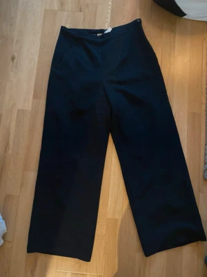 Svarta wide byxor från Claro che si - Snygga svarta byxor från Claro che si, Italien. Byxorna har en hög midja och breda ben för en chill och trendig look. Slätt foder på insidan. Perfekt för dig som gillar stilrena och bekväma plagg.