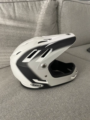 Downhill hjälm Bell - Nu säljer jag denna downhille hjälm av märket Bell i färgen svart/vit och grå. En mycket bra downhille hjälm till dig som kör downhille. Säljer den till extra billigt då säsongen nu är slut. Den är i bra skick, finns lite märken på ovansidan av hjälmen. Ny pris 899 kr från butik. Säljer den för 250 kronor men pris kan såklart diskuteras. Hjälmen har används 5-6 gånger och fungerar jätte bra. Jag är runt 165 cm lång och hjälmen sitter bra på mig.