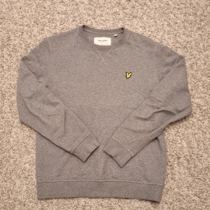 Grå sweatshirt från Lyle & Scott - Säljer en stilren grå sweatshirt från Lyle & Scott då den inte kommer till användning längre. Den har en Regular fit med rund hals och passar superbra för både en mer stilig outfit samtidigt som en mer avslappnad outfit. Den har använts några gånger och har inga defekter. Modellen är ca 180 cm lång. Skick: 8/10