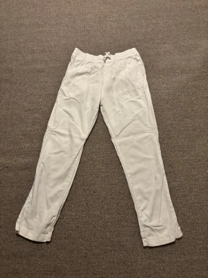 Vita linnebyxor - Snygga vita linnebyxor från Cubus i storlek M. Byxorna har elastisk midja med snörning och är gjorda i en skön blandning av linne och viskos. Perfekta för chill dagar och har en rak passform som ger en avslappnad vibe. Är använda max 3 gånger 