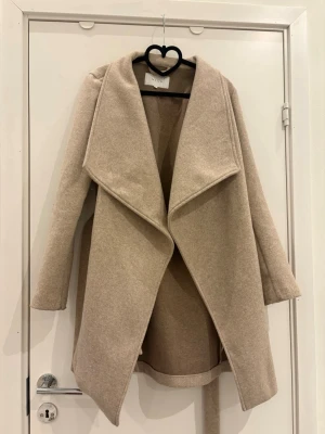 Kappa - Medellång beige kappa från vila. Bra skick, endast lite nopprig vid ärmarna, se sista bilden. Nypris ca 600, pris kan diskuteras vid snabb affär!