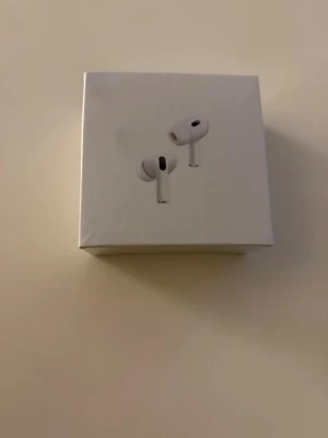 AirPods Pro 2 (USB-C) - Nya AirPods Pro 2 med USB-C och magnetiskt laddningsetui. Produkten är i originalförpackning och ser helt oanvänd ut. Perfekt för dig som vill ha aktiv brusreducering, hög ljudkvalitet och smidig laddning. Inga synliga defekter eller slitage.