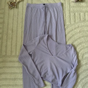 Ljuslila ribbad croppad topp - Säljer en ljuslila croppad topp med lång ärm och v-ringning. Toppen är ribbad och har en mjuk, stretchig känsla som gör den superbekväm. Perfekt för dig som gillar en enkel men trendig stil.
