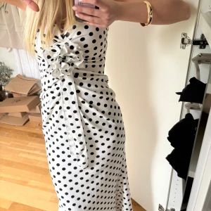 Vit prickig långklänning med volang - Supersnygg långklänning i vit med svarta prickar från prettylittlething i storlek xs