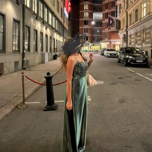 Balklänning/ långklänning  - Lång grön klänning i silke. Inbyggd bh i klänningen så funkar utmärkt att använda utan bh i eftersom den är öppen i ryggen. Banden går att justera. Känns super lyxig i tyget och har inbyggda fickor på båda sidorna som inte syns alls. Endast använd 1 gång. Kostar mellan 3500-4000kr ny. 