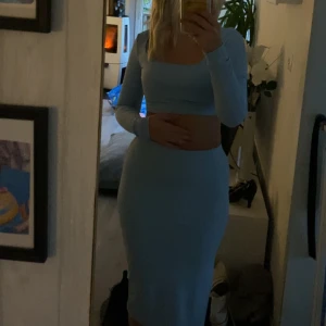 Ljusblå ribbad långklänning - Säljer mitt gulliga ljusblåa set. Kjolen går ungefär till knäna. Båda plagen är i s och är använda en gång💙