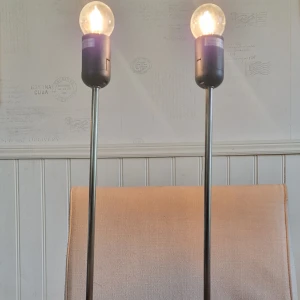 E27 Bordslampa, 2-pack - Snygga bordslampor med E27-sockel, max 60W, 230V~50Hz. Modern design med metall och trädetaljer i foten. Lamporna är i gott skick men på en foten syns slitage i form av två fläckar som inte går bort men också små prickar invid trädetaljer på den nedersta delen av foten. Perfekt för vardagsrum eller sovrum. Säljes som 2-pack. Glödlamporna ingår ej.
