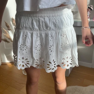 Vita broderad kjol med inbyggda shorts. - Superfin kjol med broderade blommor och volangkant. De har resår och är gjorda i bomull. Perfekta för sommaren och ger en söt och luftig look.