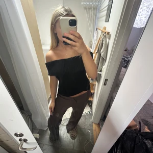 Svart ribbad offshoulder stickad topp - Säljer denna skitsnygga och trendiga svarta stickade topp med ribbad struktur och offshoulder-design. Använd en gång! Från Nelly, nypris 400kr