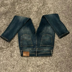 Jack & Jones Tapered Mike jeans 28/30 - Mörkblå jeans från Jack & Jones, modell Tapered Mike. Klassisk femficksdesign med två stora bakfickor och snygga slitningar. Tapered passform som smalnar av nedtill. Tillverkade i slitstarkt denim med kontrastsömmar. Nypris 600