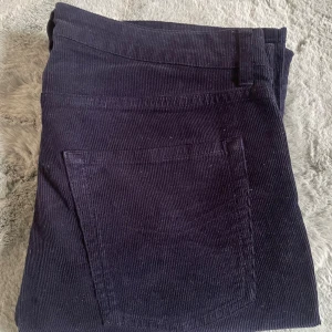 Mörkblå manchesterbyxor från Zadig & Voltaire - Snygga mörkblå manchesterbyxor från Zadig och Voltaire med klassiska fickor och detaljer i metall. Byxorna har en slim passform och är tillverkade i mjuk manchester som ger en retrovibe. Perfekta för dig som gillar stilrena och bekväma byxor.