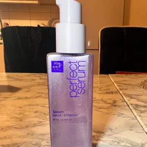 Perfect Serum Magic Straight Mise-en-scene  80ml - Lila skimrande pumpflaska med 80 ml serum från Mise en Scène. Perfekt för att ge håret en slät och glansig finish. Flaskan är stilren och lätt att använda med sin praktiska pump. Passar dig som vill ha ett magiskt rakt resultat.