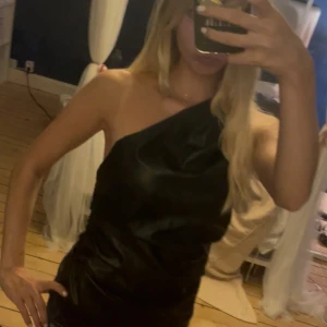 Svart oneshoulder topp i fakeläder - Säljer en svart, oneshoulder topp i fakeläder material från ZARA. Endast testad aldrig använd.💕