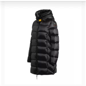 Parajumper Marion jacka - Säljer en svart lång dunjacka från Parajumpers med ikonisk gul detalj vid kragen och patch på ärmen. Jackan har quiltad design, dragkedja framtill och hög krage. Perfekt för kalla dagar och riktigt snygg streetstil. Använd 3 vintrar, i bra skick. Storlek S.