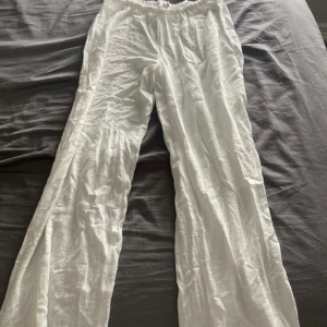 Vita linnebyxor från Nelly med snörning - Luftiga vita linnebyxor från Nelly i storlek S. Byxorna har resår i midjan och snörning framtill för en skön passform. De är raka i modellen och tillverkade i tunt, svalt linnetyg – perfekta för varma dagar. Aldrig använda 🩷