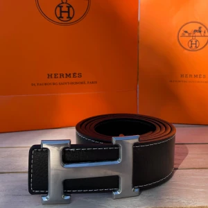 H Bälte Svart - Säljer ett svart bälte med ett silvrigt snyggt ”H” spänne. Bältet har en längd på 105 cm (storlek 42) och är Inte använt en enda gång, tveka inte att fråga! 💯👌 