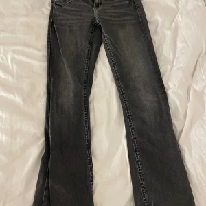 Svarta bootcut jeans Gina Tricot 164 - Snygga svarta jeans från Gina Tricot i storlek 164. Modellen har bootcut-ben och klassisk femficksdesign. Jeansen är i stretchigt denimtyg och har en cool tvättad look med ljusare partier framtill.